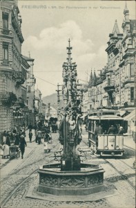 Alte Ansichtskarte Freiburg i. Br., Der Fischbrunnen in der Kaiserstrasse mit Straßenbahn